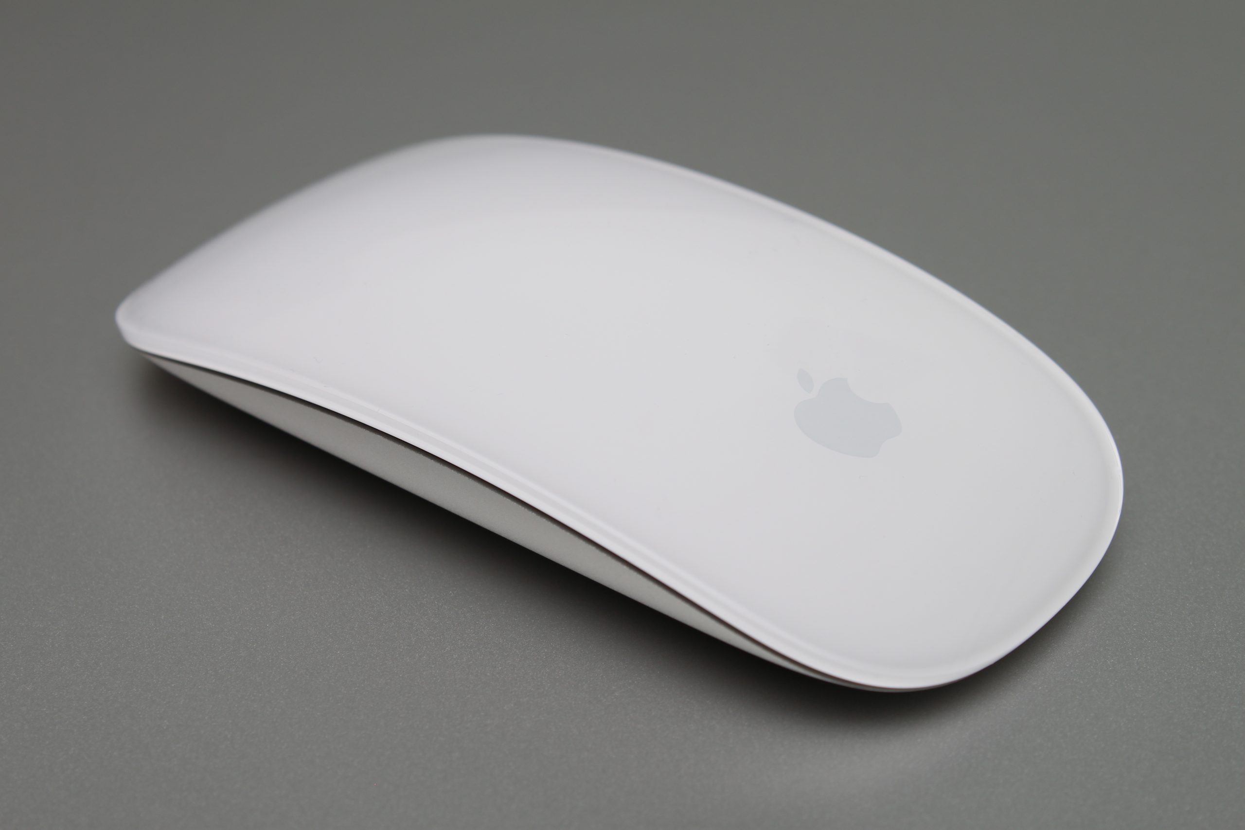 Apple Magic Mouse on a modern minimalist wooden desk setup